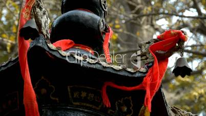 Dragon and metal bell on censer tower,Red ribbon blowing in wind,Trees,shade.