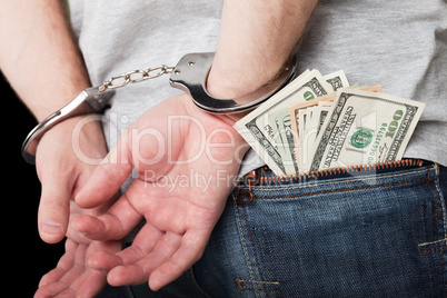 Handcuffs on hands hiding money