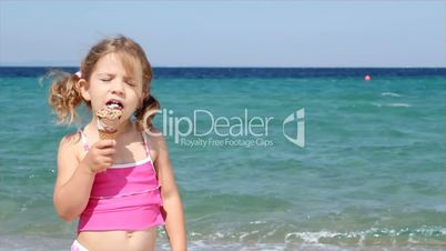 little girl eat ice cream on beach