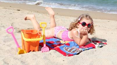 little girl lying on the beach