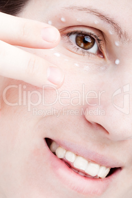 Women applying eye skin cream