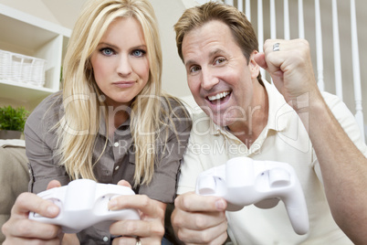 Married Couple Having Fun Playing Video Console Game