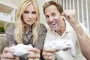 Married Couple Having Fun Playing Video Console Game