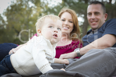 Cute Child Looks Up to Sky as Young Parents Smile