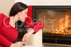Attractive woman looking into fireplace cozy home