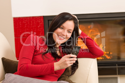 Fireplace woman with phone lying home sofa