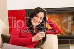 Fireplace woman with phone lying home sofa