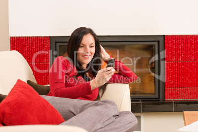 Fireplace woman with phone lying home sofa