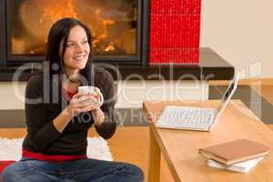 Home living woman with laptop by fireplace