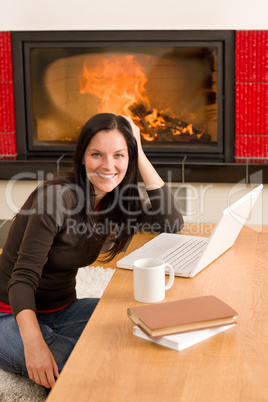 Home living woman with laptop by fireplace