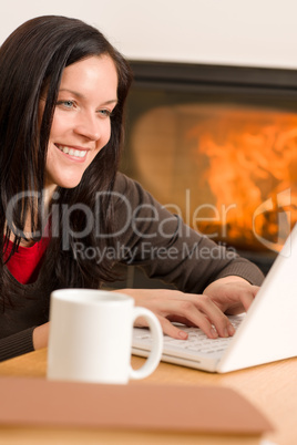 Home living woman with laptop by fireplace