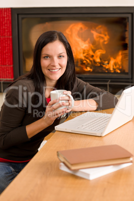 Home living woman with laptop by fireplace