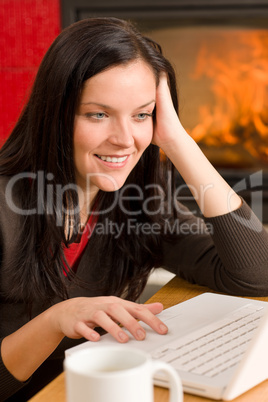 Home living woman with laptop by fireplace