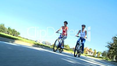 Fit Young Female Friends Cycling Together