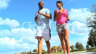 African American Couple Jogging on Suburban Road