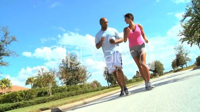 Ethnic Female Jogging with Personal Trainer