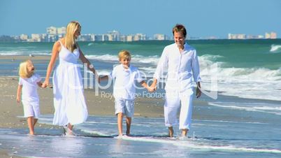 Young Caucasian Family Walking Beach Together