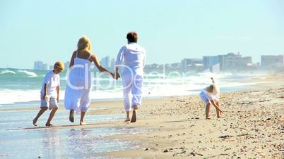 Young Caucasian Family Running on Beach