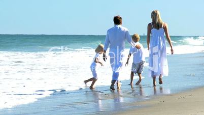 Happy Caucasian Family Splashing in Ocean Shallows