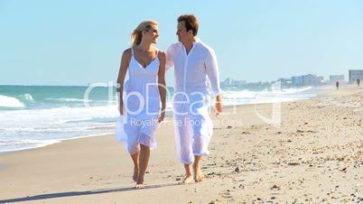 Young Caucasian Couple Walking on the Beach
