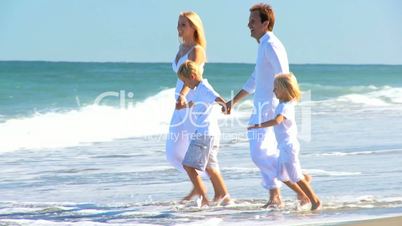 Happy Caucasian Family Splashing in Ocean Shallows