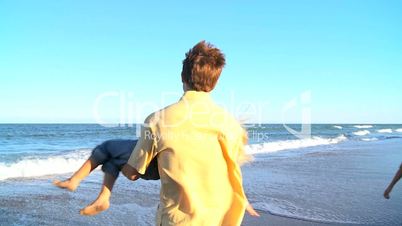 Caucasian Parents Playing with Their Children on Beach