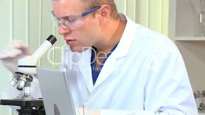 Male Student Researcher with Microscope in Hospital Lab