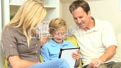 Young Blonde Boy Using Wireless Tablet with Parents