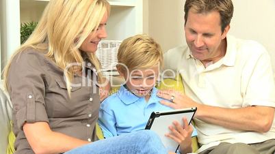 Young Blonde Boy Using Wireless Tablet with Parents