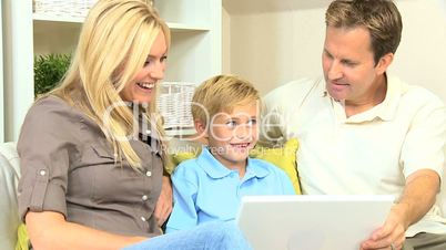 Young Caucasian Boy Using Laptop with Parents