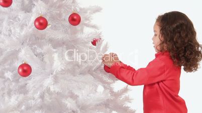 Little girl decorating a christmas tree