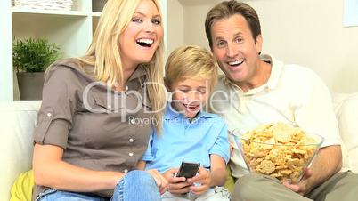 Young Family Watching Movie Together with Snacks