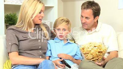 Attractive Family Enjoying TV & Snack Food