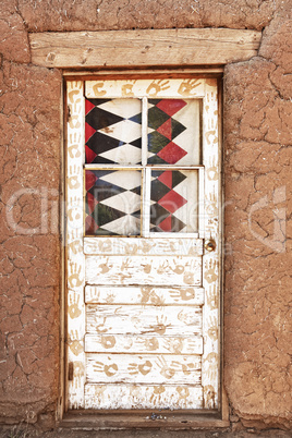 Decorated Door and Adobe Building