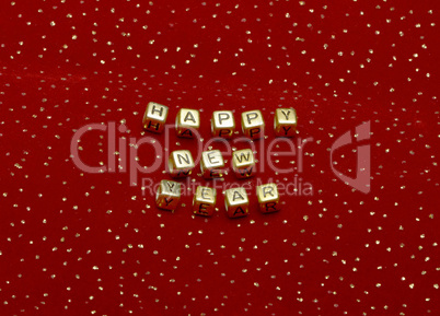 phrase "happy new year" of beads on a red velvet with sequins