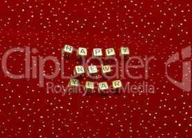 phrase "happy new year" of beads on a red velvet with sequins