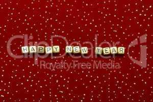 phrase "happy new year" of beads on a red velvet with sequins