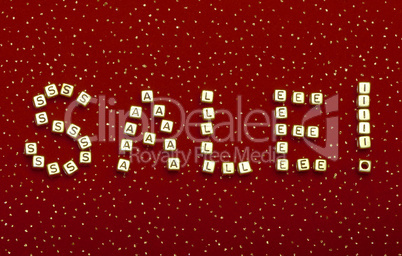 word "SALE" of beads on a red velvet with sequins