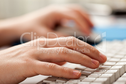 Holding mouse hand typing computer keyboard