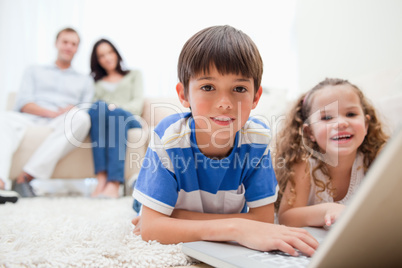 Cute kids playing computer games on laptop