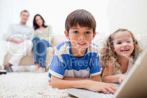 Cute kids playing computer games on laptop