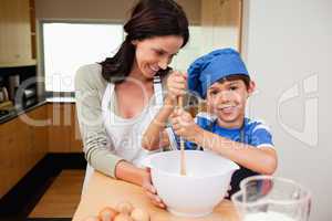 Mother and son having fun preparing a cake
