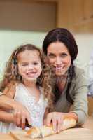 Mother and daughter slicing bread