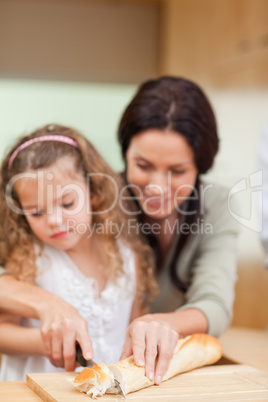 Mother and daughter cutting bread