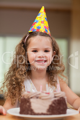 Girl with a slice of cake in front of her