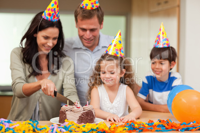 Mother cutting birthday cake