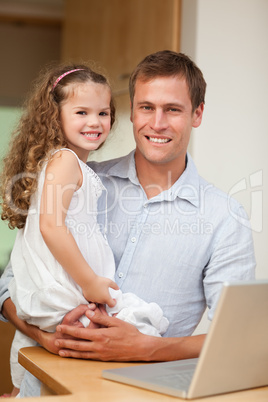 Father showing laptop to his daughter
