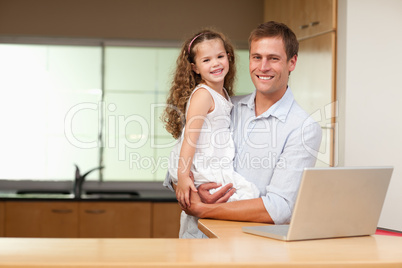 Father carrying his daughter on his arms