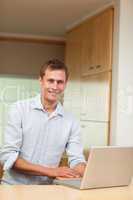 Man using laptop in the kitchen