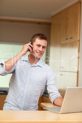 Male with laptop and cellphone in the kitchen